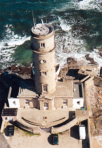 L’ancien phare vu du nouveau phare, à environ mi-chemin de sa hauteur, aujourd’hui sémaphore de la marine nationale. Erigé en 1774-1775, il a fonctionné jusqu’à la mise en service du nouveau phare en avril 1835. Avec le quatrième étage, qui a remplacé la lanterne au moment de sa transformation en sémaphore, ce phare a une hauteur de 28 mètres. On aperçoit derrière la tour, face au large, la chambre de veille panoramique construite en 1968. (Photo François de Lannoy © Patrimoine Normand)