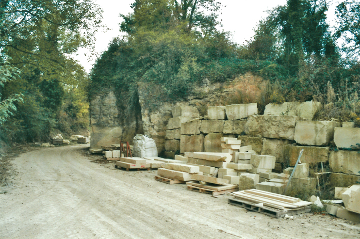 Abords de la carrière de Cintheaux (Calvados). Derrière les pierres taillées, la roche brute révèle ses différentes couches différemment exploitables. (Photo Thierry Georges Leprévost © Patrimoine Normand)