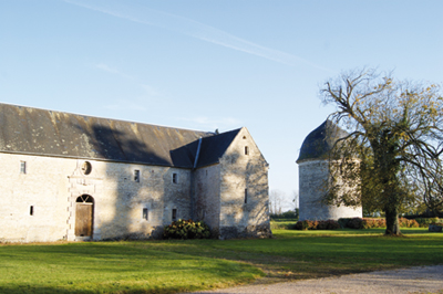 Depuis la cour du château de Jucoville, le bâtiment oriental des communs, XVe siècle, avec reprises au XVIIe et au XIXe siècles, et la tour-pigeonnier. (Photo Georges Bernage   Patrimoine Normand)