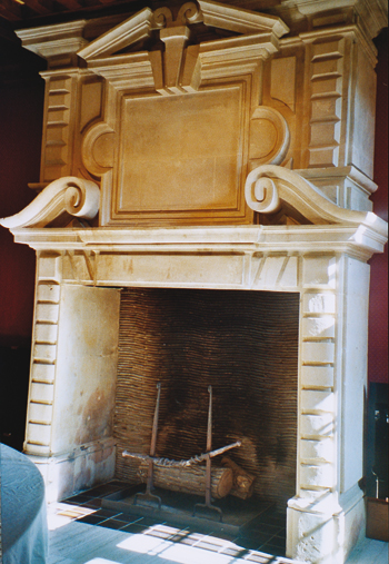 L’imposante cheminée en pierre de Caen. Son manteau et les piédroits comportent un décor de bossages. (© Lucia Minart)