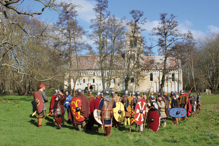 Devant l’église romane de Thaon, le réalisateur prodigue ses conseils à l’armée carolingienne. (Photo Thierry Georges Leprévost © Patrimoine Normand