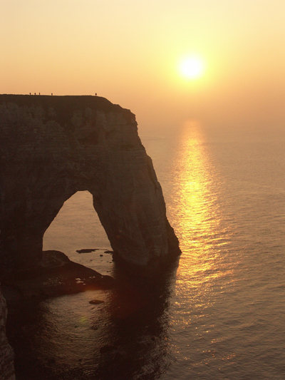  Le soleil, plus bas, semblait saigner ; et une large traînée lumineuse, une route éblouissante courait sur l`eau depuis la limite de l`Océan jusqu`au sillage de la barque.  ( Stéphane William Gond