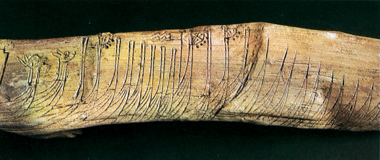 Une flotte nordique gravée sur une pièce de bois d’environ 18 centimètres de long, découverte à Bergen et datée du XIIIe siècle. On remarque encore des proues en forme de têtes d’animaux ou de dragons et des girouettes. (­­© Statens Historika, Stockholm)