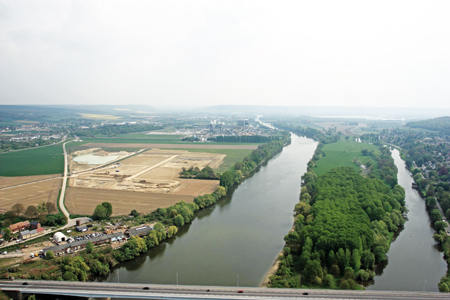Vue générale du site, sur la rive droite de la Seine, entre le pont de Pont-de-l'Arche et la zone industrielle d'Alizay. Au fond, la vallée de l'Andelle. (© Jacques Refuveille, Balloïde)