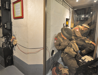 Accompagné de trois soldats, le lieutenant Bob Orrell parvient au bout de quatre heures à forcer l'entrée d'une étrange construction du Mur de l'Atlantique. Les hommes trébuchent sur deux caisses de grenades, quand une voix en provenance des étages leur demande dans un anglais parfait de monter les rejoindre. L'officier britannique retourne l'invitation en les conviant à descendre ! Près de quatre jours après le Débarquement, il reçoit ainsi la reddition des 52 occupants du Grand Bunker.(Photo Rodolphe Corbin © Patrimoine Normand)