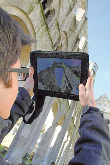 Visiteur de l'abbaye de Jumièges avec une tablette. (© Véronique Hénon - CD76)