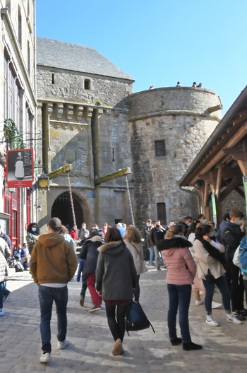 Derrière la barbacane se dresse un nouvel obstacle, l’un des plus beaux éléments des défenses du Mont : la Porte du Roi. Elle est précédée par un fossé qui a été rétabli ainsi que par un pont-levis charretier et un pont à bascule arrière piétonnier. Elle a aussi été édifiée dans les années 1410-1420. (Photo Rodolphe Corbin © Patrimoine Normand)