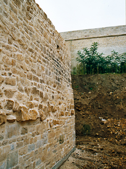 L’escalier dont la dalle sculptée constituait une marche se trouvait adossé à ce mur de la maison médiévale mise au jour au cours des fouilles préventives. (Photo Thierry Georges Leprévost © Patrimoine Normand)
