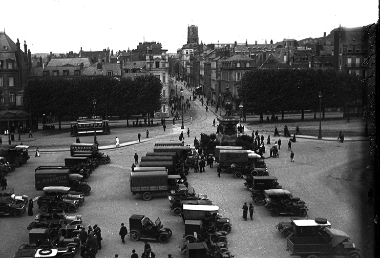 Devant l’hôtel de ville de Rouen, au pied de la statue de Napoléon, les véhicules réquisitionnés sont parqués avant de partir au front, en août 1914. (Archives départementales de Seine-Maritime).