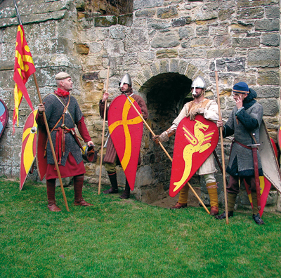 Les Normands au pied des ruines de l'abbaye de Battle, qui dominent le champ de bataille, édifiée à l’emplacement de la position saxonne, là où périt le roi Harold. (© Jeannine Bavay)