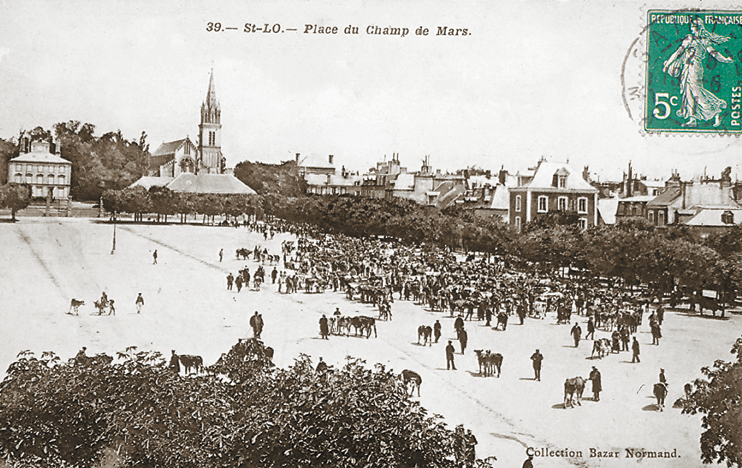 La place du Champ de Mars, au pied de la citadelle hors l’Enclos. On aperçoit au fond l’ancien haras à gauche et l’église Sainte-Croix à droite. Le Champ de Mars est de nos jours occupé par le musée des Beaux-Arts et le Centre Culturel. (Carte postale © Archives Départementales de la Manche, Saint-Lô.)