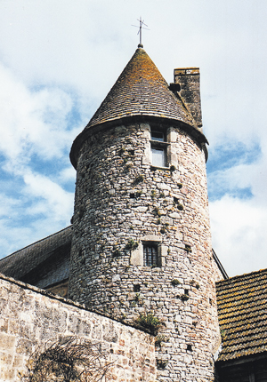 Château de Crosville. Belle tour du XVe siècle, ronde et élancée, dominant l’entrée, à l’angle sud-est de la cour fermée : fenêtre chanfreinée et fenêtre à meneau simple. La toiture est en «?pierre », couverte de laxxes de schiste typique du Nord-Cotentin. (Photo Georges Bernage © Patrimoine Normand)